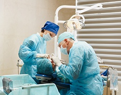 A dentist and assistant perform dental implant surgery on a patient in Thorndale