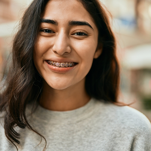 Young woman with braces and gray shirt