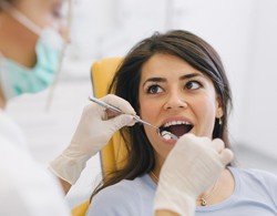 A woman having her teeth checked at the dentist office