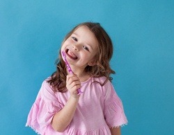 A little girl holding a toothbrush