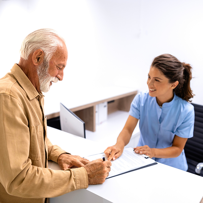 Senior man checking in at front desk of dental office