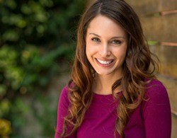 A woman smiling after dental bridge restoration