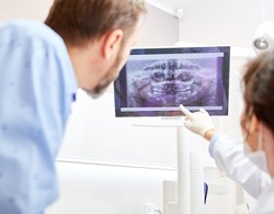 Dentist and patient reviewing x-rays during dental consultation