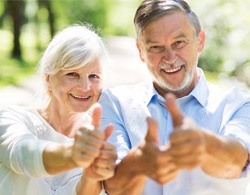 Older couple giving the thumbs up