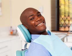 Man smiles after getting dental implant supported dentures in Thorndale