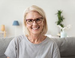 Woman with flawless smile after dental implant tooth replacement