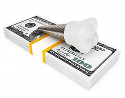 Model implant and money representing the cost of dental implants in Coatesville