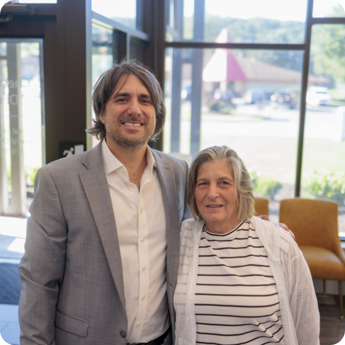 Implant patient smiling with Dr. Simeone