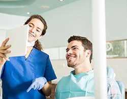 Dentist showing patient image on tablet