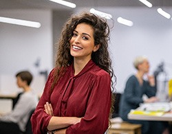 Young woman smiling at work while wearing an Invisalign aligner in Thorndale