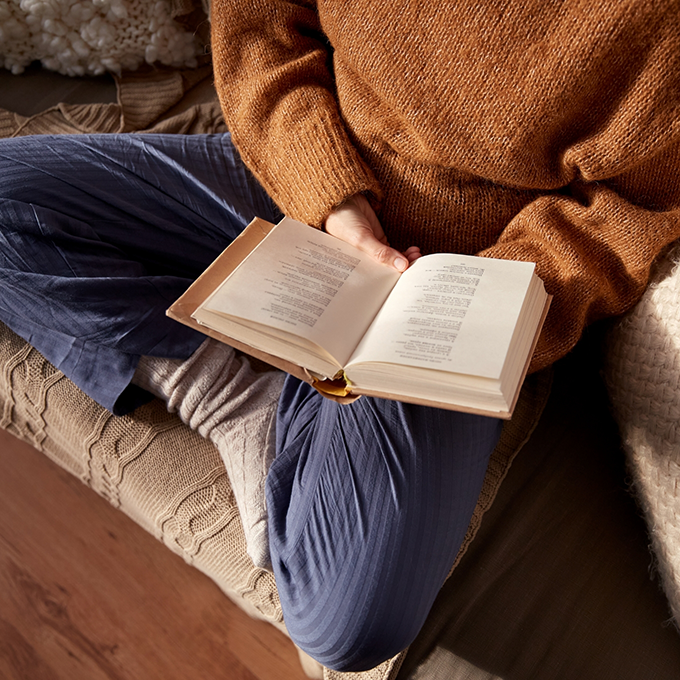 Person sitting on couch with book in lap