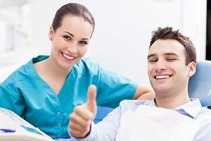 Man in dental chair giving thumbs up