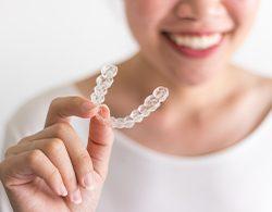 Young person holding Invisalign Teen aligner