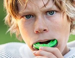 Teen boy placing mouthguard
