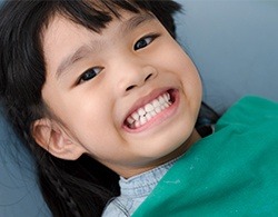 Young girl in dental chair smiling after children's dentistry