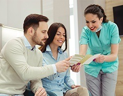 Dental team member showing patients dental insurance forms