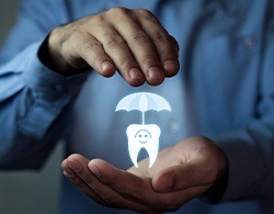 Hands holding an animated tooth and umbrella