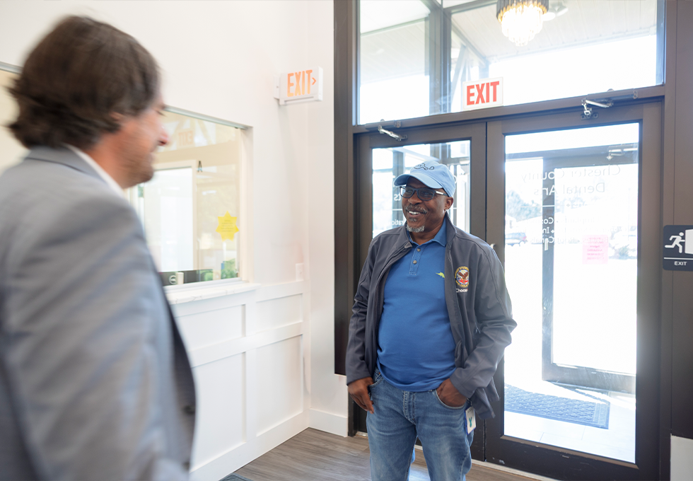 Man with blue cap walking into dental office