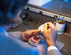 Man wearing glasses smiling after restorative dentistry