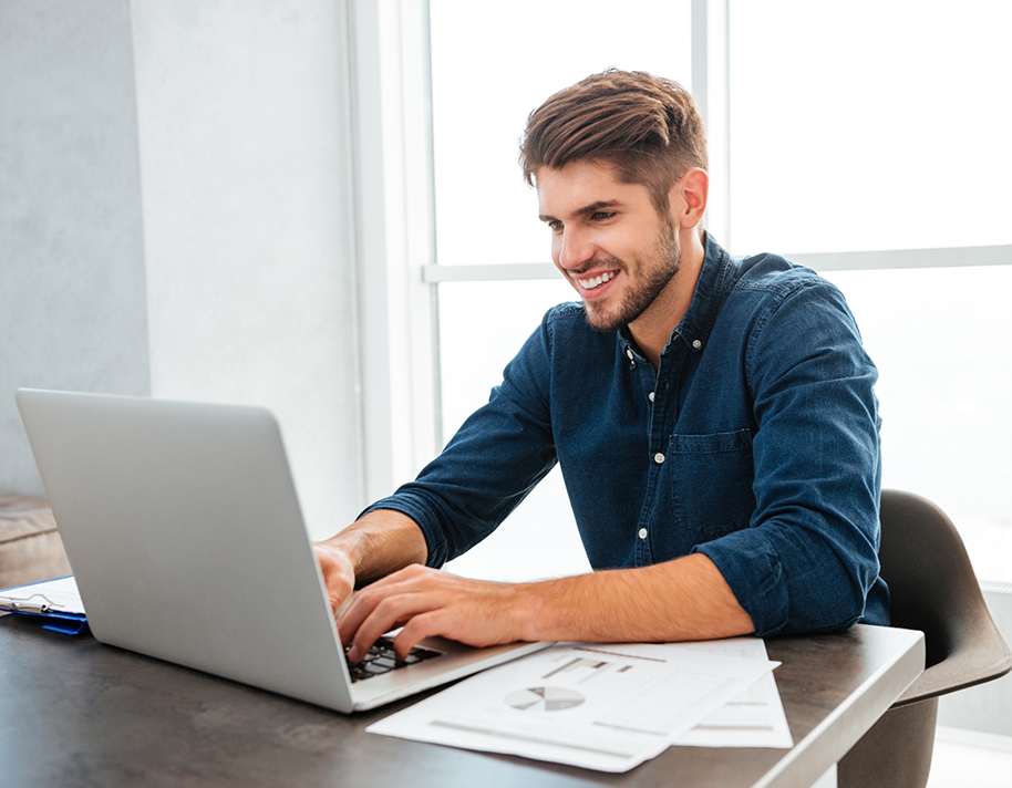Smiling man sitting at laptop