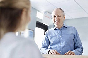 A man speaking with a dental employee