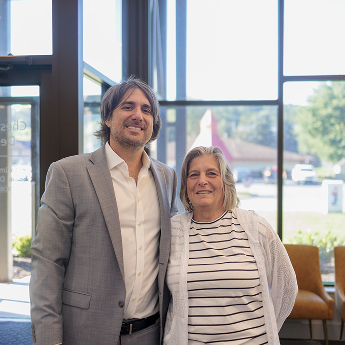 Older man and woman standing in dental office and smiling