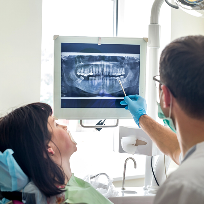 Dentist showing patient X ray of mouth