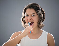 Woman brushing teeth before preventive dentistry visit