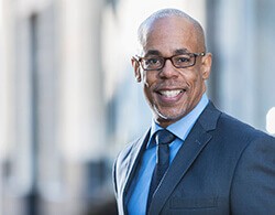 Man wearing glasses smiling after restorative dentistry