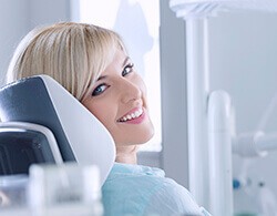 Woman looking sideways, smiling while receiving dental services in Thorndale