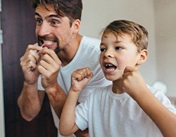 father and son flossing teeth