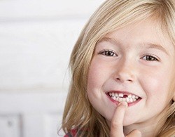 young girl showing knocked out tooth