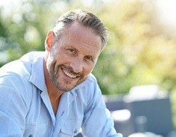 Person with porcelain veneers outside smiling