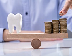 Tooth being balanced with a pile of coins