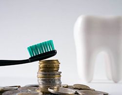 Tooth next to a pile of coins