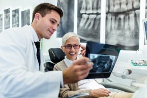 A dentist showing a patient an X-ray.