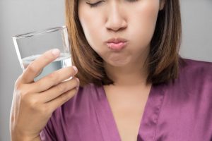 a woman gargling with a liquid substance