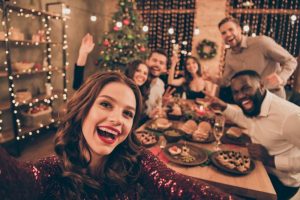 a group of friends smiling around the table during the holidays 