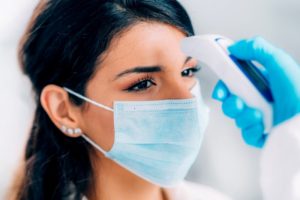 Patient getting their temperature taken before dental appointment