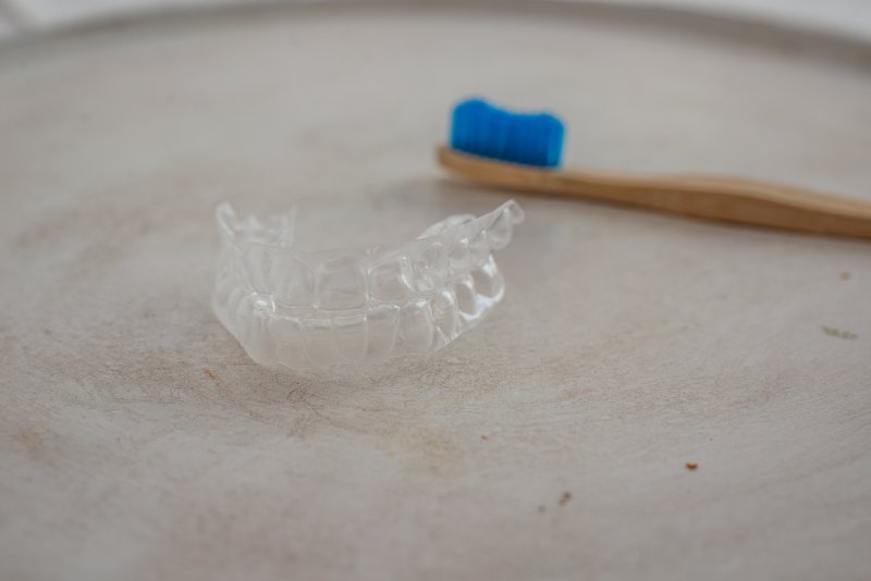 a set of Invisalign aligners and a manual toothbrush 