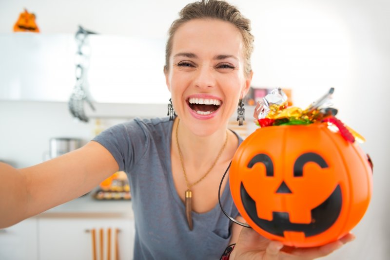 Woman holding bucket of Halloween candy 