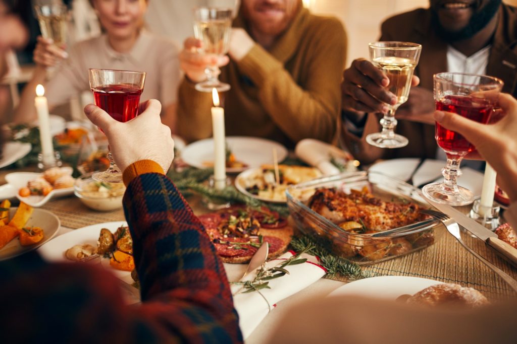 Closeup of friends toasting over holiday dinner