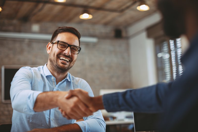 Man shaking hands with client after Invisalign treatment