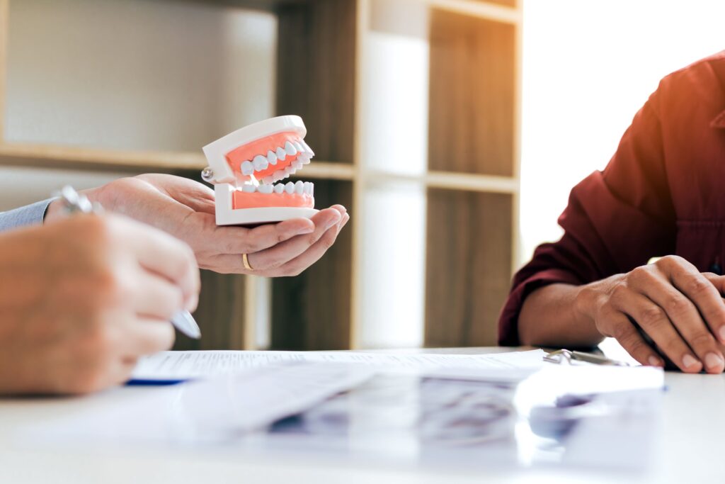Hands of dentist and patient discussing replacement teeth over X-rays