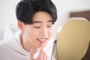 Man looking at his teeth in the mirror